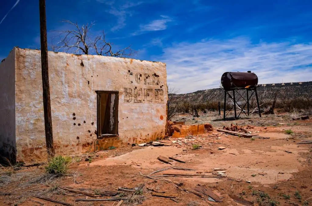 an abandoned red adobe store in the desert